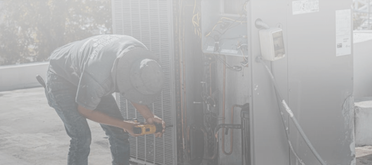 A Commercial Building with A Rooftop Unit Being Repaired by HVAC Tech
